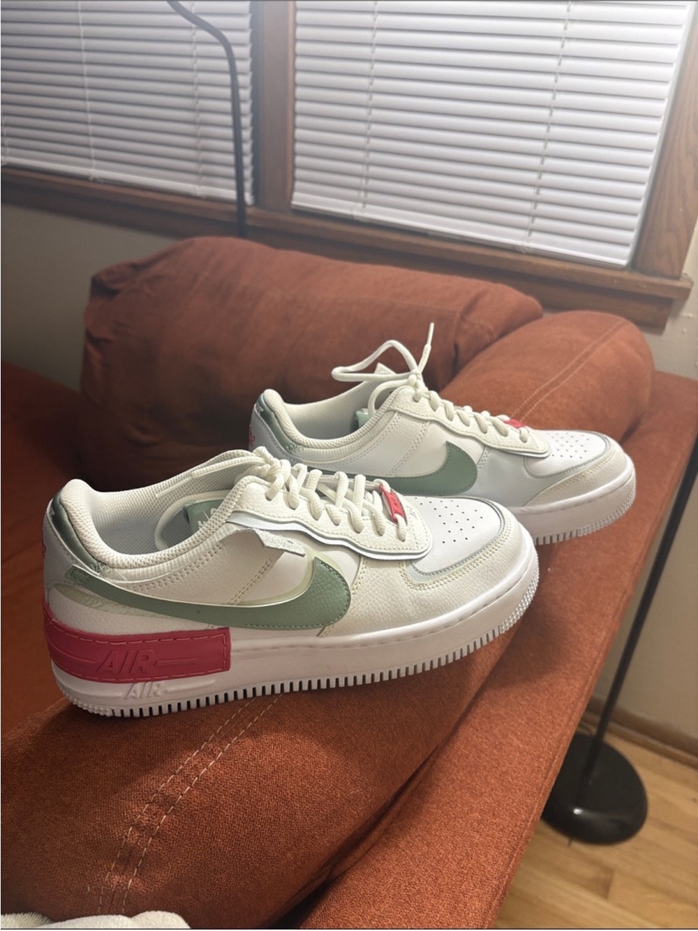 Nike Women's White Sneakers with Sage Green Swoosh and Pink Heel Accent